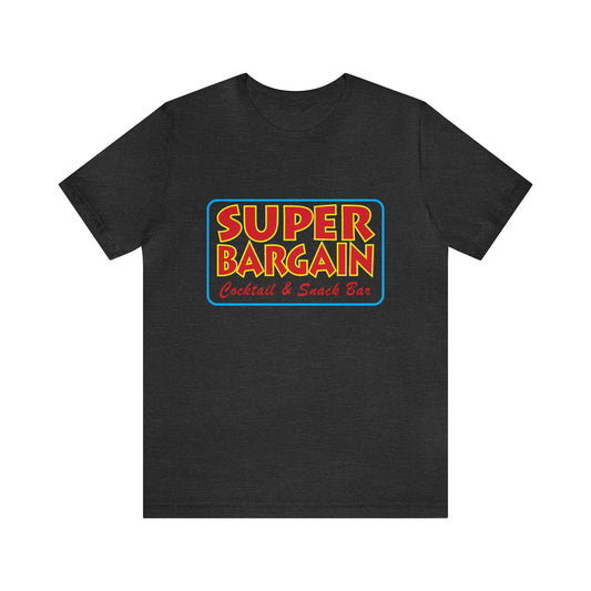 A dark gray Unisex Jersey Short Sleeve Tee with a colorful logo that reads "SUPER BARGAIN Cocktail & Snack Bar" in bold yellow, blue, and red font, centered on the chest area. Celebrating Cabbagetown, Toronto. (Printify)