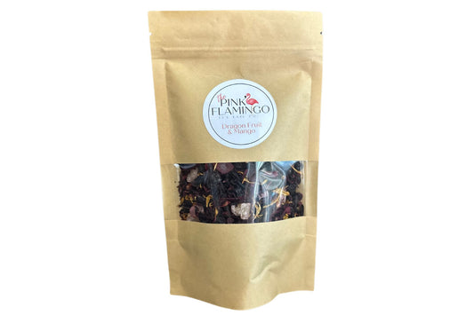 A sealed paper bag labeled "Pink Flamingo Dragon Fruit & Mango Tropical Tea" with a clear window displaying dried fruit pieces inside. The label features a pink and white color scheme.