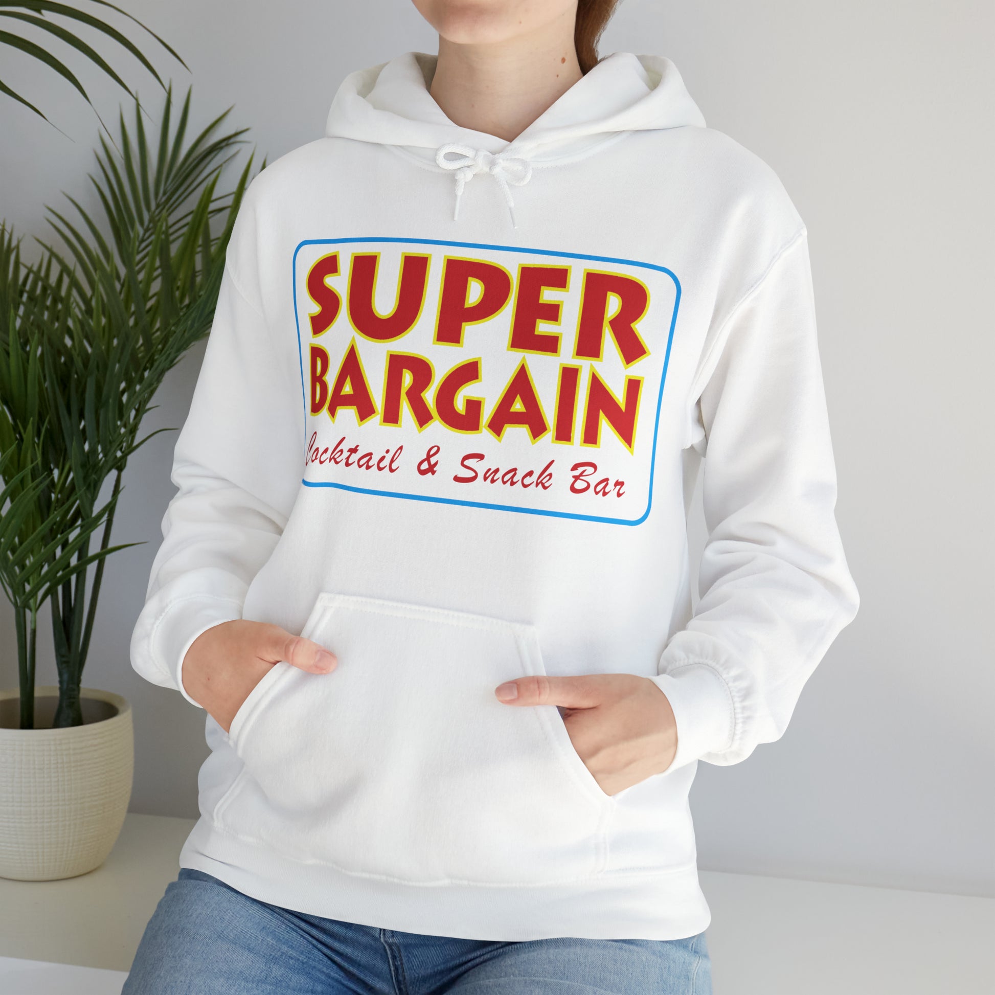 A person wearing a white hoodie with "Cabbagetown SUPER BARGAIN Cocktail & Snack Bar" printed in colorful letters on the chest, standing against a white background. Hands are partially tucked into Printify's Unisex Heavy Blend™ Hooded Sweatshirt's front pocket.