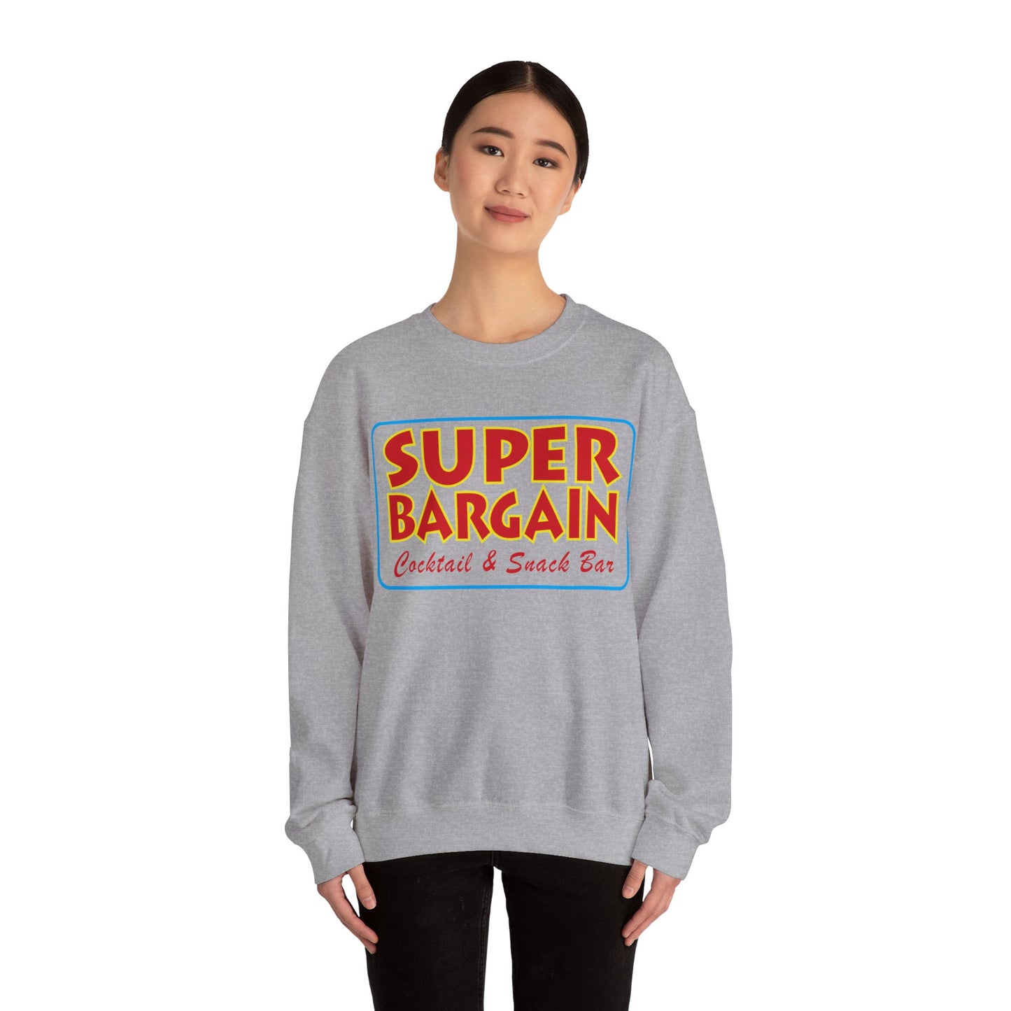 A young woman wearing a gray Unisex Heavy Blend™ Crewneck Signature Logo Sweatshirt by Printify that reads "SUPER BARGAIN Cocktail & Snack Bar" in colorful letters. She appears calm, with a slight smile, and stands against a white background in Cabbagetown, Toronto.