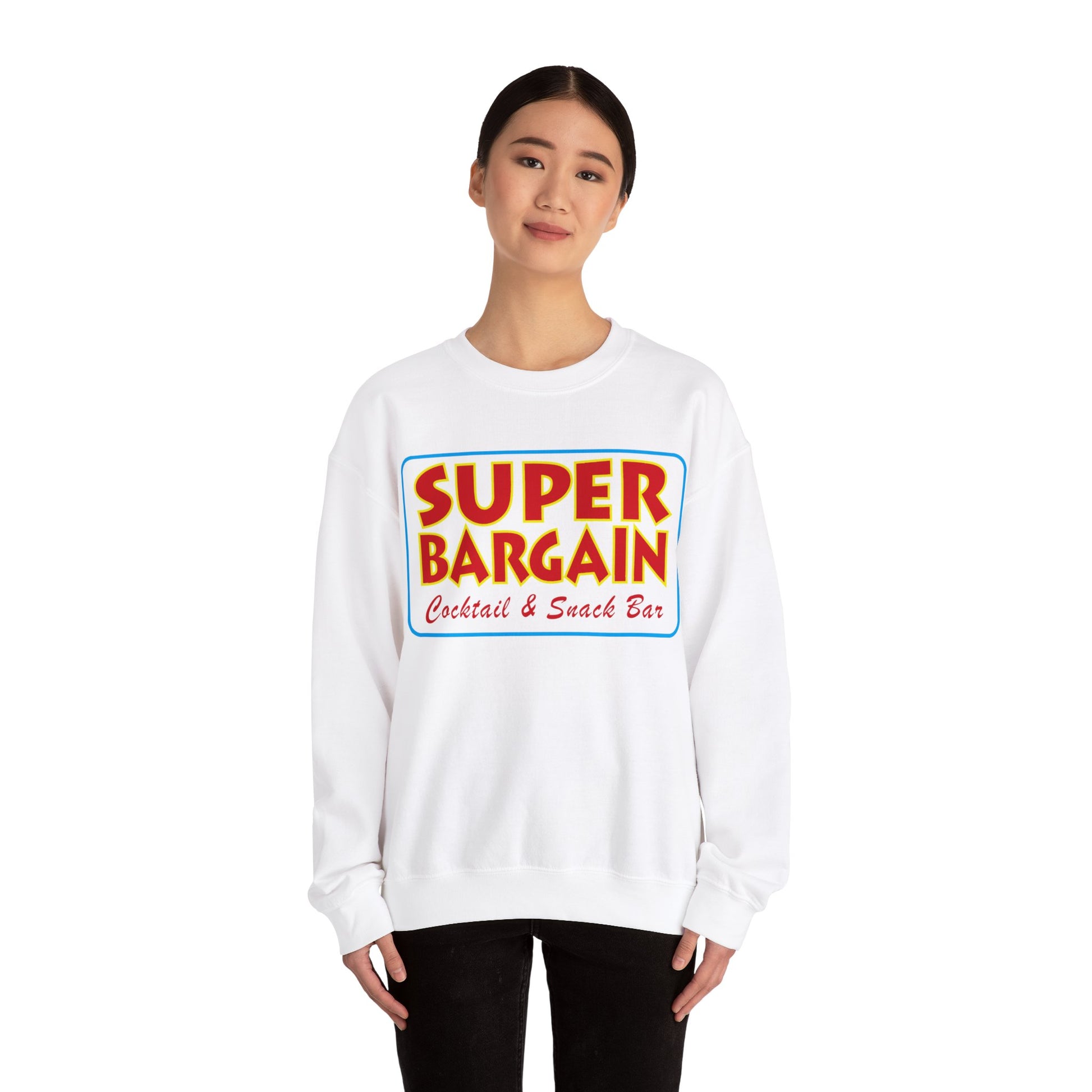 A woman wearing a white Unisex Heavy Blend™ Crewneck Signature Logo Sweatshirt from Printify, with the colorful text "SUPER BARGAIN Cocktail & Snack Bar, Cabbagetown Toronto" printed on the front, standing against a plain background.