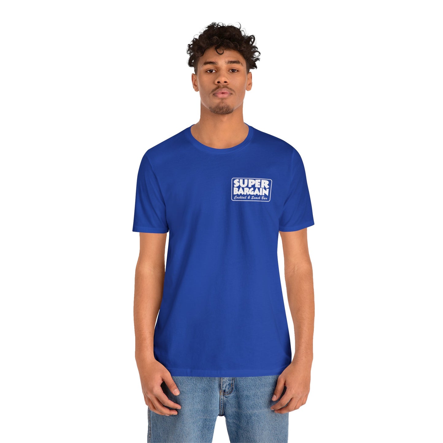 A young man in a bright blue t-shirt with the text "SUPER BARGAIN" printed on the chest, paired with light blue jeans, standing against a white background in Cabbagetown, Toronto. The t-shirt is a Printify Unisex Jersey Short Sleeve Monochrome Logo Tee.