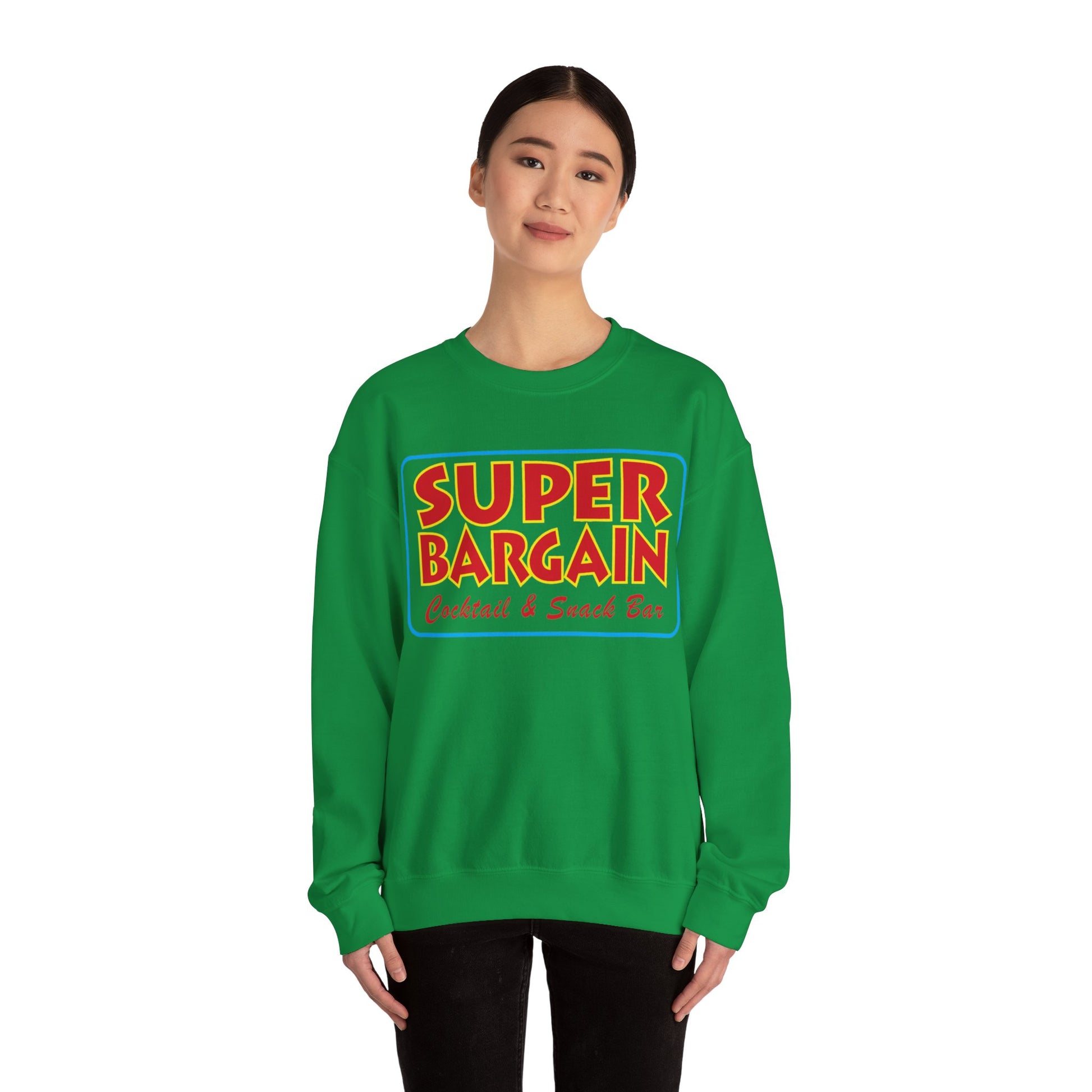 A woman in a green Unisex Heavy Blend™ Crewneck Signature Logo Sweatshirt with the words "SUPER BARGAIN Cocktails & Snack Bar" printed in colorful letters on the front, strolls through Cabbagetown, Toronto.