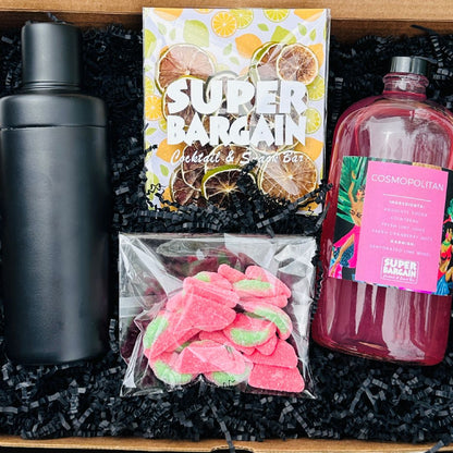 A large ready-to-drink cosmopolitan gift box featuring a stylish design, containing 1 large bottles of 8 pre-mixed cosmopolitan cocktails and accompanying garnishes, a sweet or savory treat and a matte cocktail shaker.